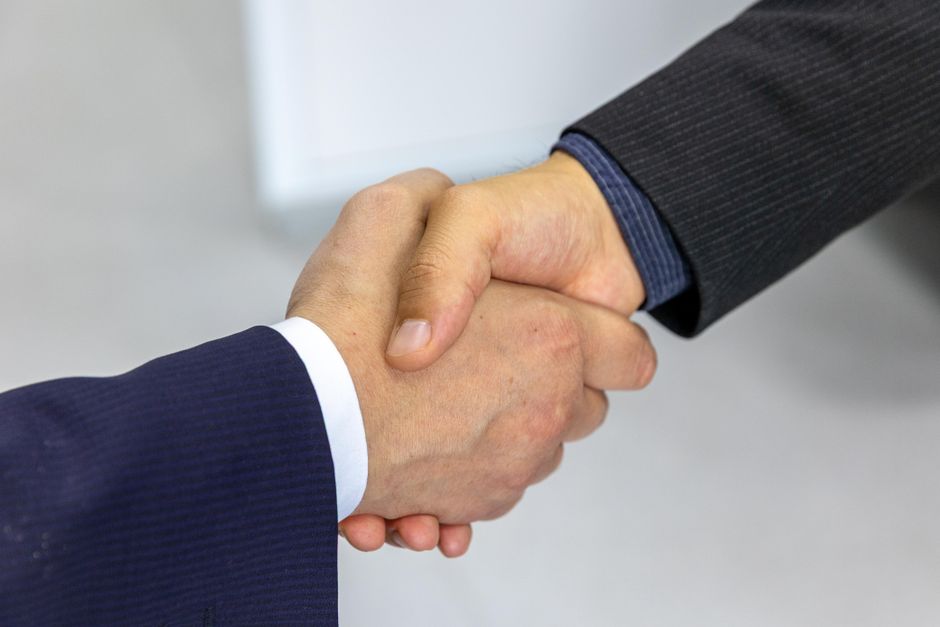 Property manager and owner shaking hands over a management agreement